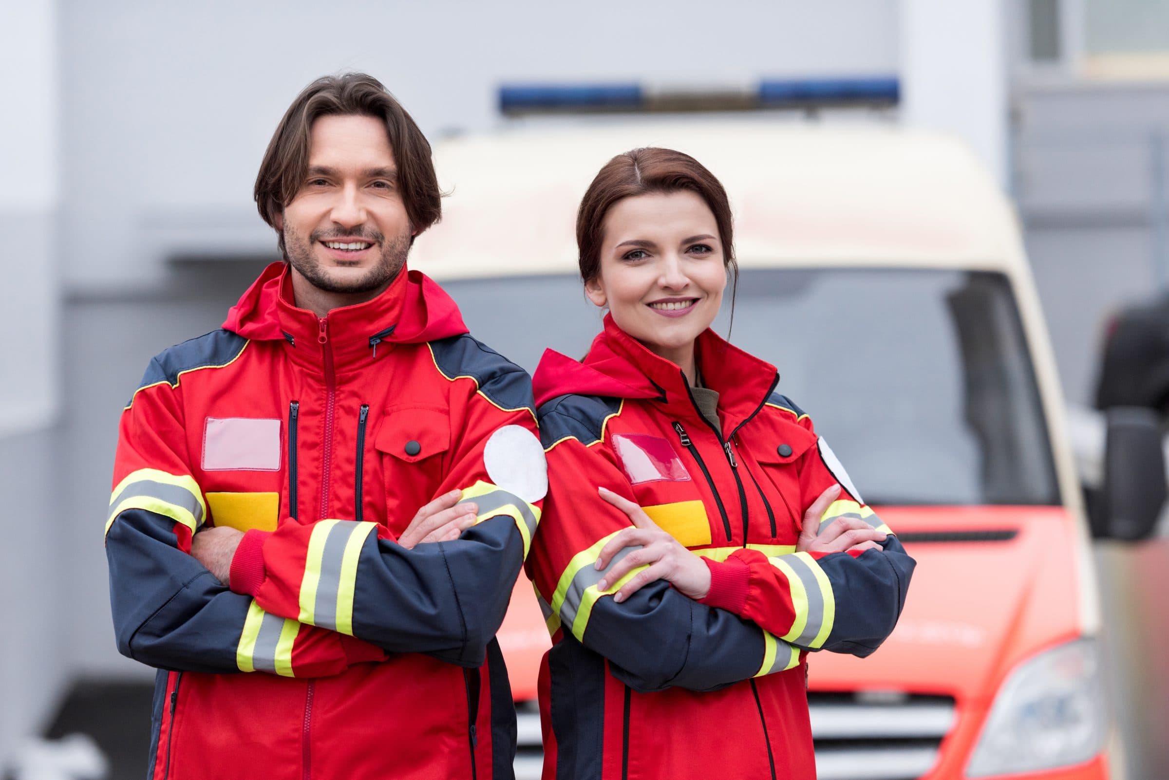 Lachendes Sanitäter-Team in roter Einsatzkleidung